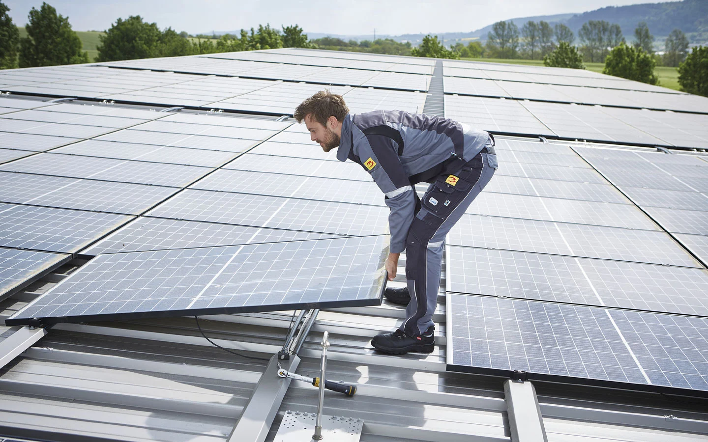 E-CHECK PV - Mitarbeiter installiert Solarzellen auf dem Dach · B+B Mess- und Sicherheitstechnik